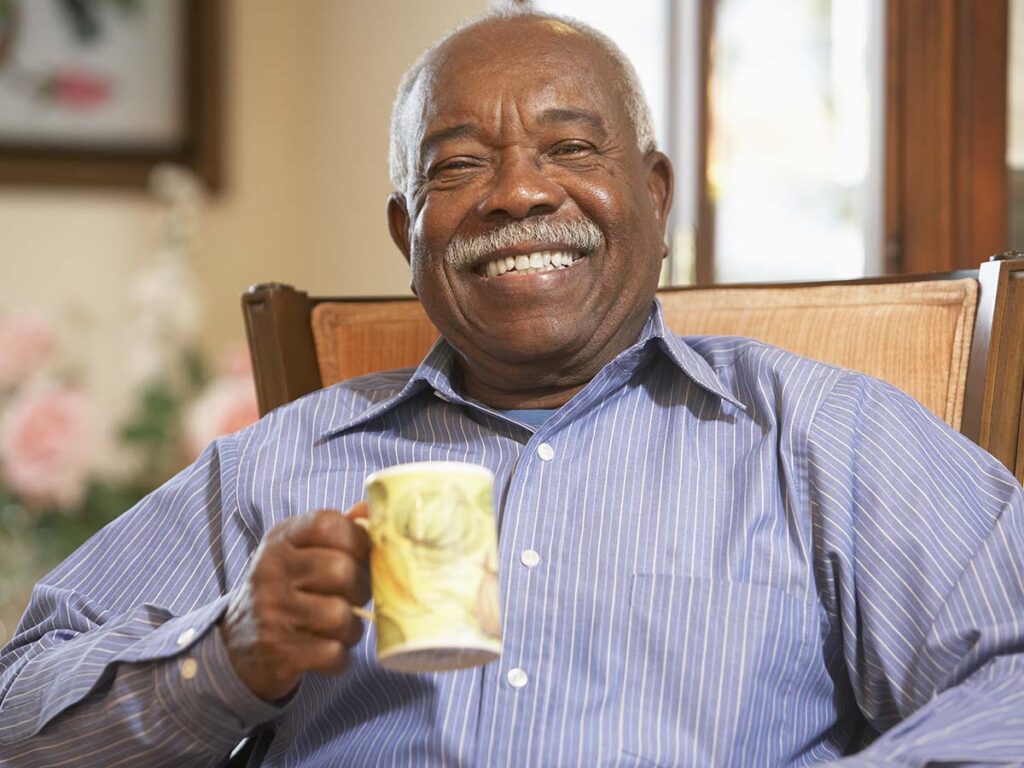 Senior man smiling and drinking coffee