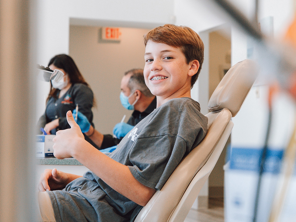 happy teen in dentist chair