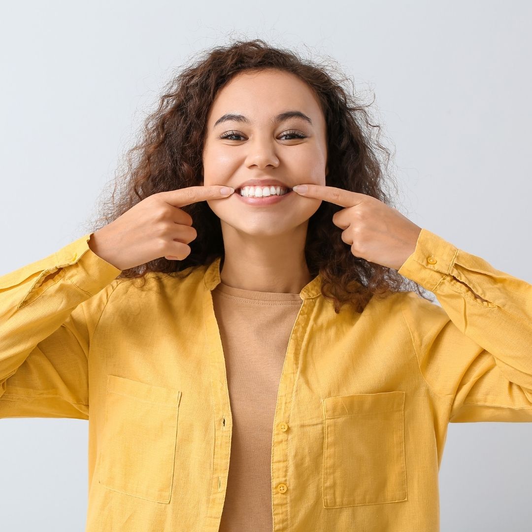 smiling woman pointing at teeth