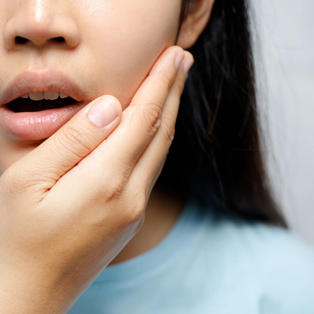person holding jaw in pain