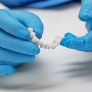 dentist holding dental bridge
