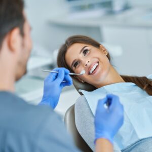 woman in dental chair smiling at dentist