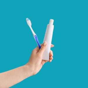 hand holding tooth brush and tooth paste