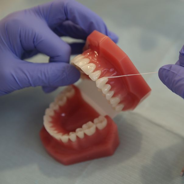 Dental assistant flossing dentures