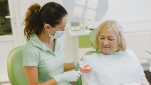 Elderly woman discussing dentures with dentist