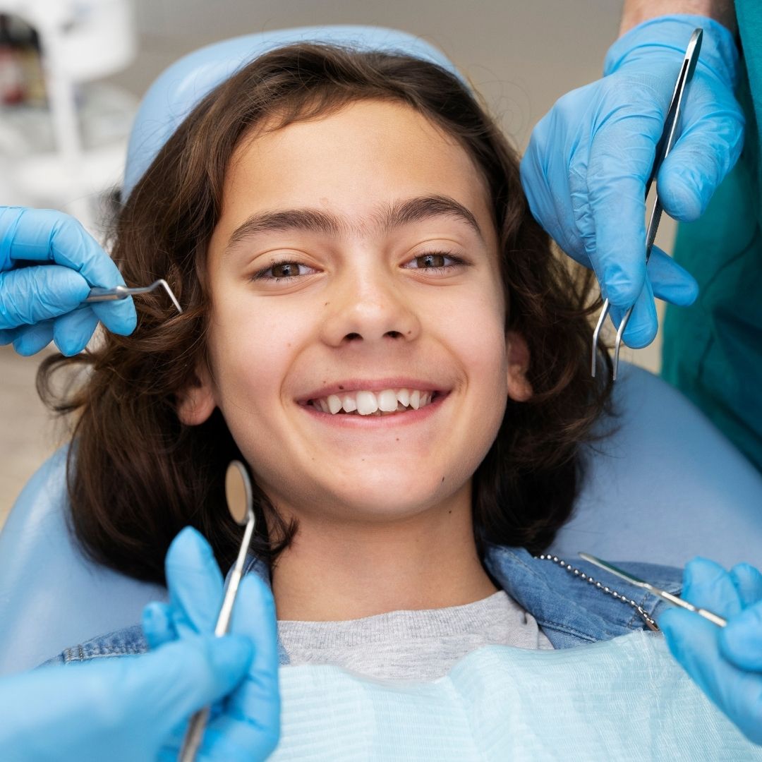 young boy smiling from dentist chair
