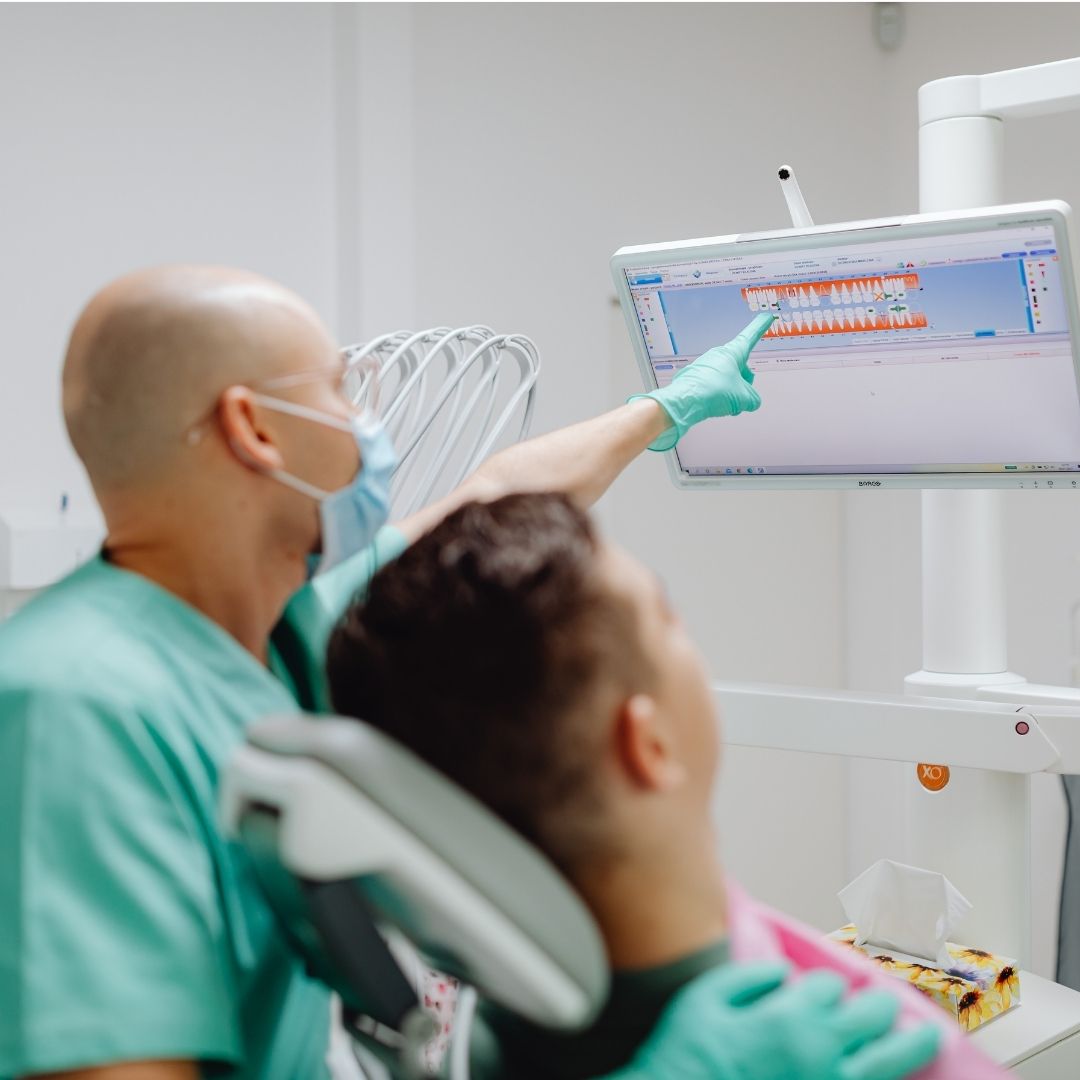dentist showing a patient something on a screen